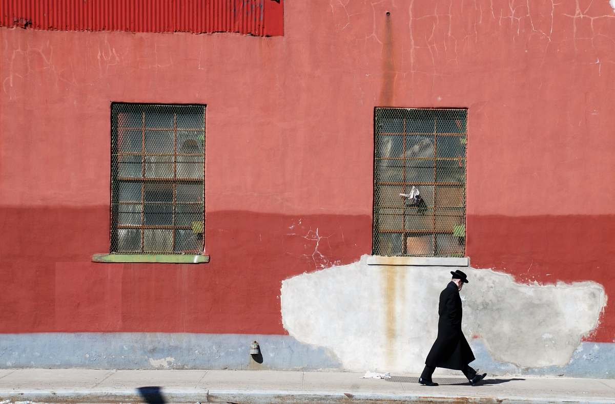 brooklyn man walking beside red wall storm